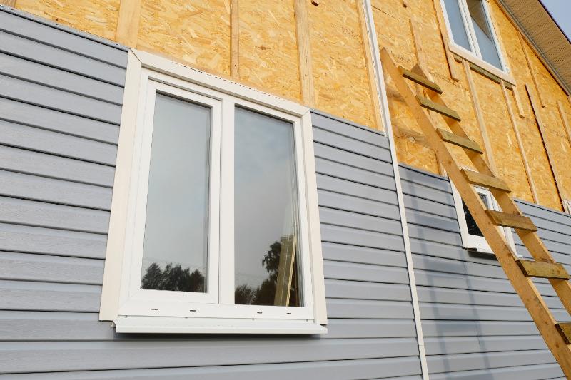 Pose de bardage bois naturel sur façade par charpentier expert