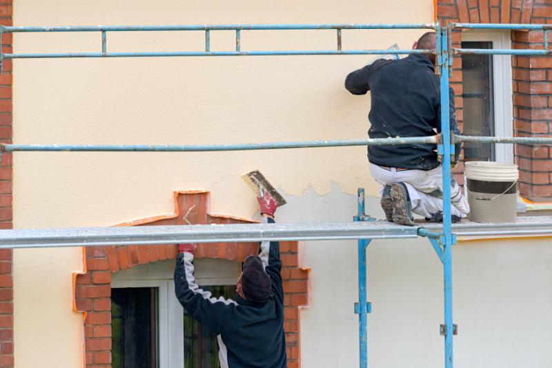 Application d'enduit de façade neuf sur mur extérieur rénové