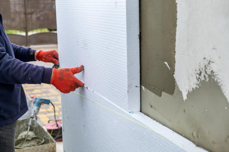 Chantier d'isolation extérieure avec échafaudage et matériaux isolants haute performance