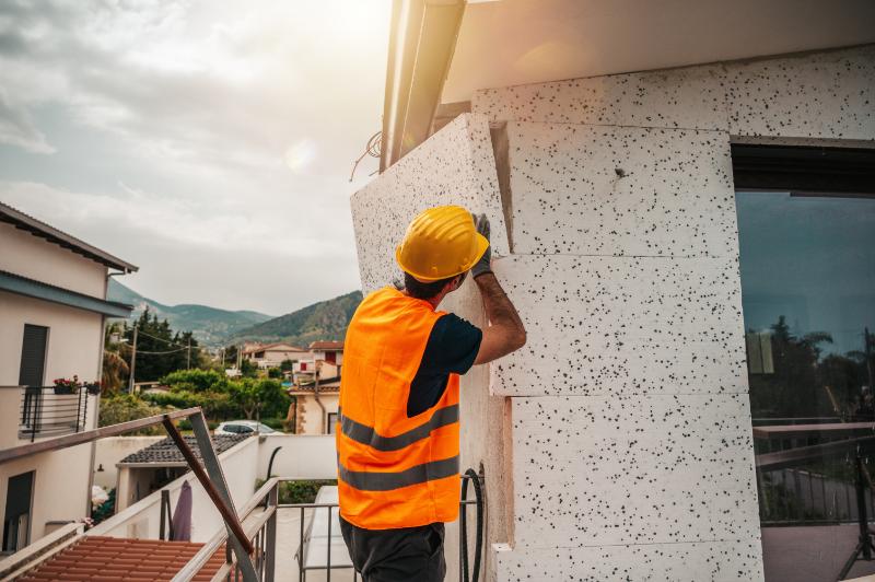Pose d'isolant polystyrène sur mur extérieur par artisan qualifié RGE